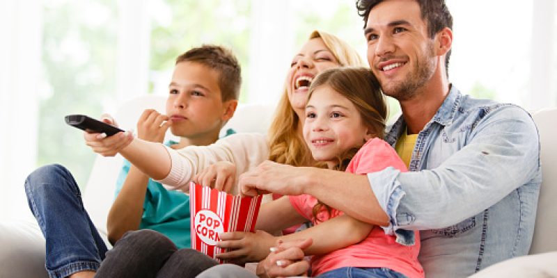 Family watching television in living room